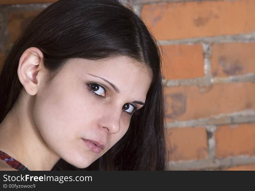 Headshot of a beautiful young brunette woman in front of a grungy brick background. Headshot of a beautiful young brunette woman in front of a grungy brick background.