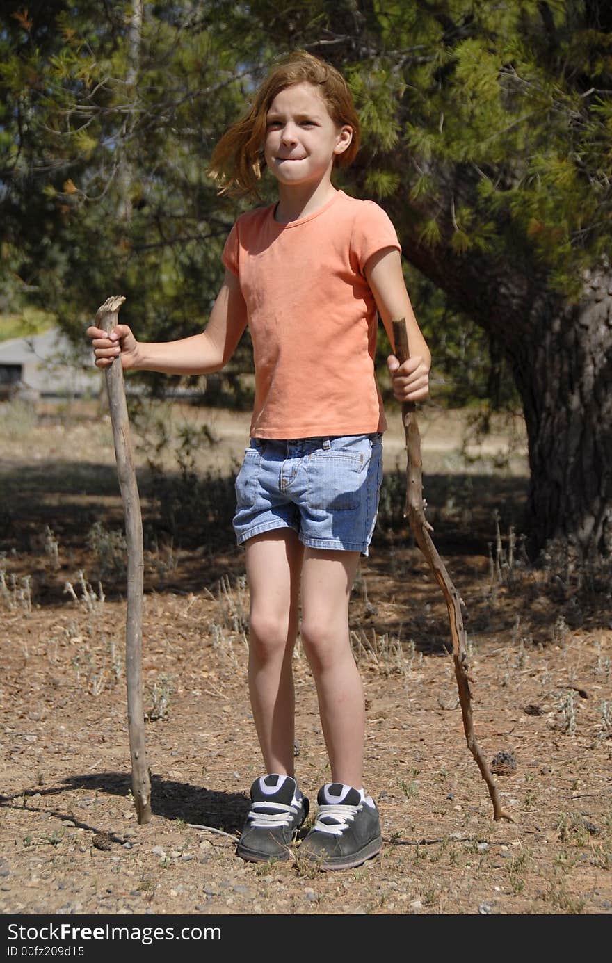 A girl with 2 sticks in the park