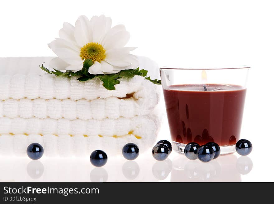 Towels, candle, and daisy on white isolated. Towels, candle, and daisy on white isolated