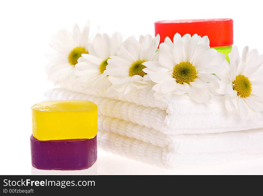 Towels, soap bars, and daisies on white isolated. Towels, soap bars, and daisies on white isolated