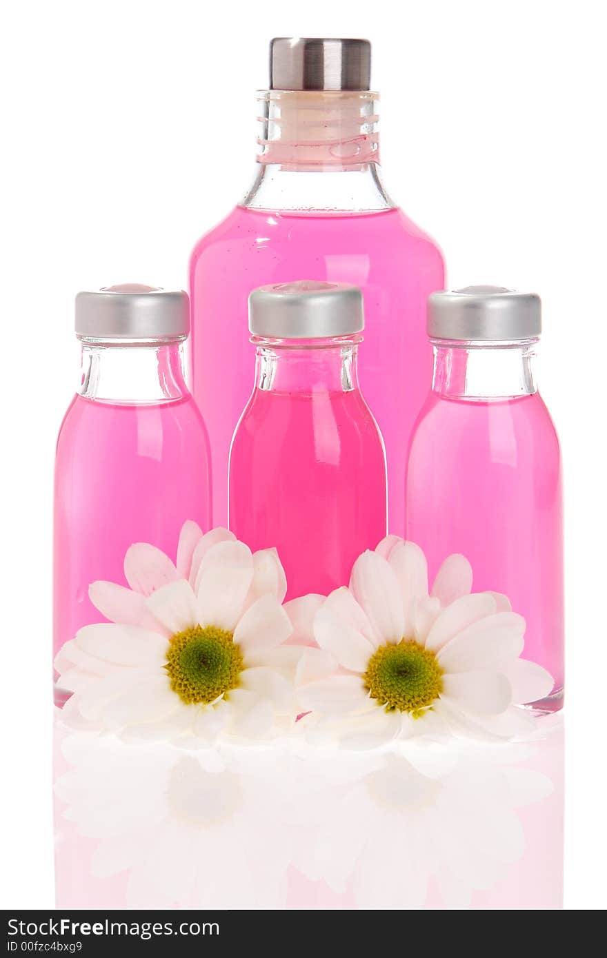 Spa bottles and daisies isolated on white background. Spa bottles and daisies isolated on white background