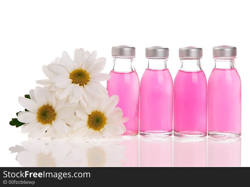 Spa bottles and daisies isolated on white background. Spa bottles and daisies isolated on white background