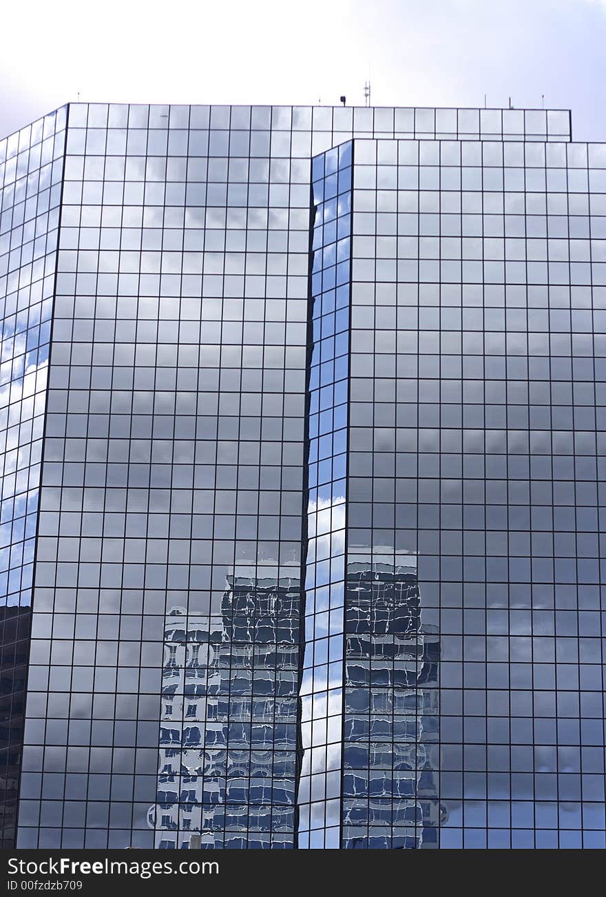 A modern office building in a sprawling urban area with reflection. A modern office building in a sprawling urban area with reflection