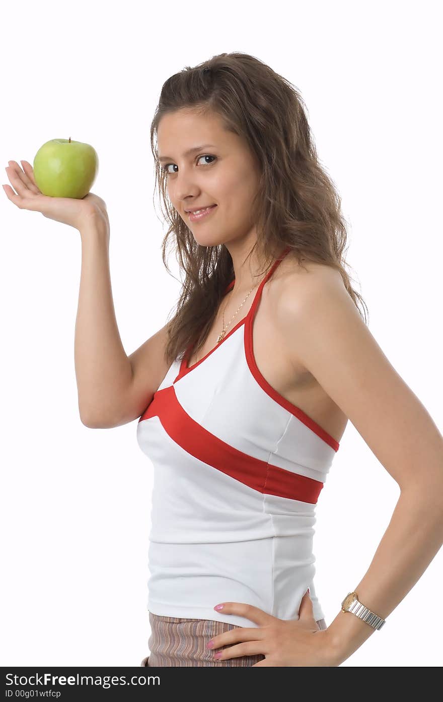 The brown-eyed girl holds a green apple in hands. The brown-eyed girl holds a green apple in hands