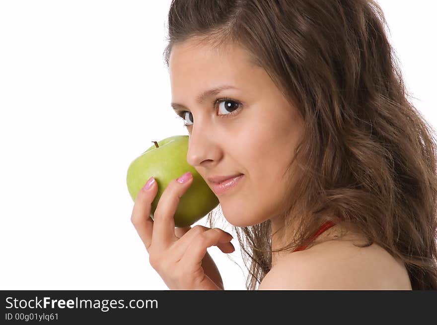 The brown-eyed girl holds a green apple in hands. The brown-eyed girl holds a green apple in hands