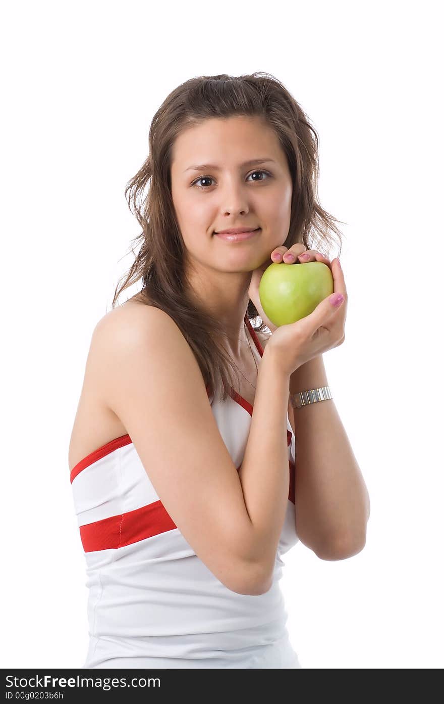 The brown-eyed girl holds a green apple in hands. The brown-eyed girl holds a green apple in hands