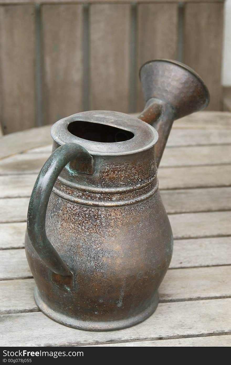 Isolated garden watering jug on wood table