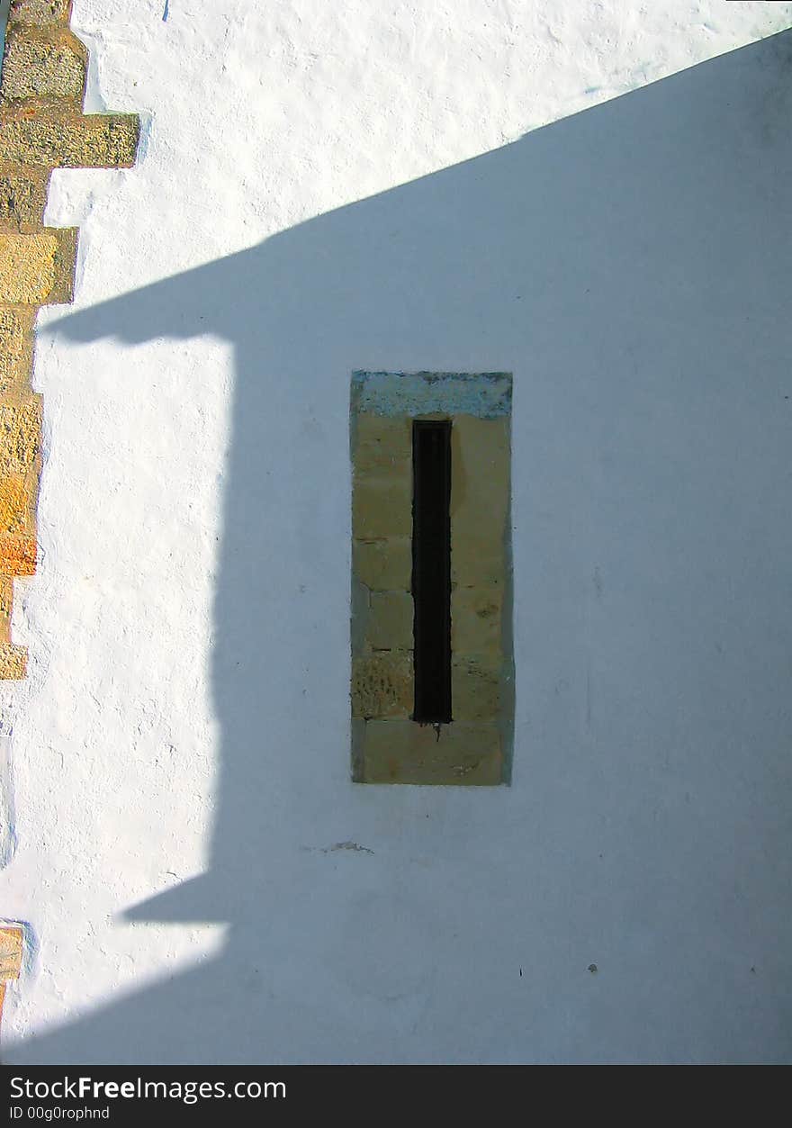 The narrow view of this church window in the shade of another house almost defeats all hope of a view. Alcácer do Sal, Portugal.