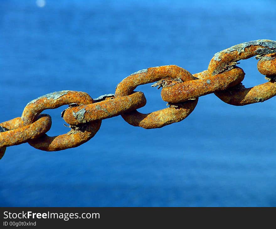 Macro view of a few rusty metal chain ring in high tension