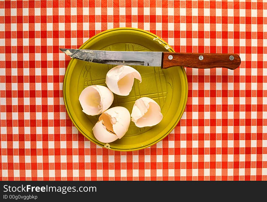 Preparation of  fried eggs,  stayed shell from eggs and  knife on red cloth. Preparation of  fried eggs,  stayed shell from eggs and  knife on red cloth