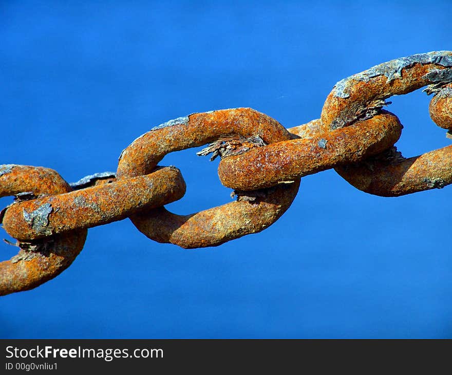 Macro view of a few rusty metal chain ring in high tension