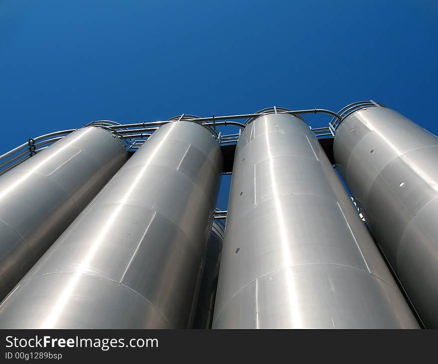 Tanks of silvery color, are photographed on a background of the blue sky. Tanks of silvery color, are photographed on a background of the blue sky