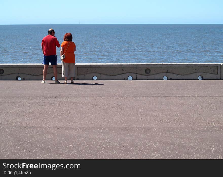 Couple looking out to sea from promenade