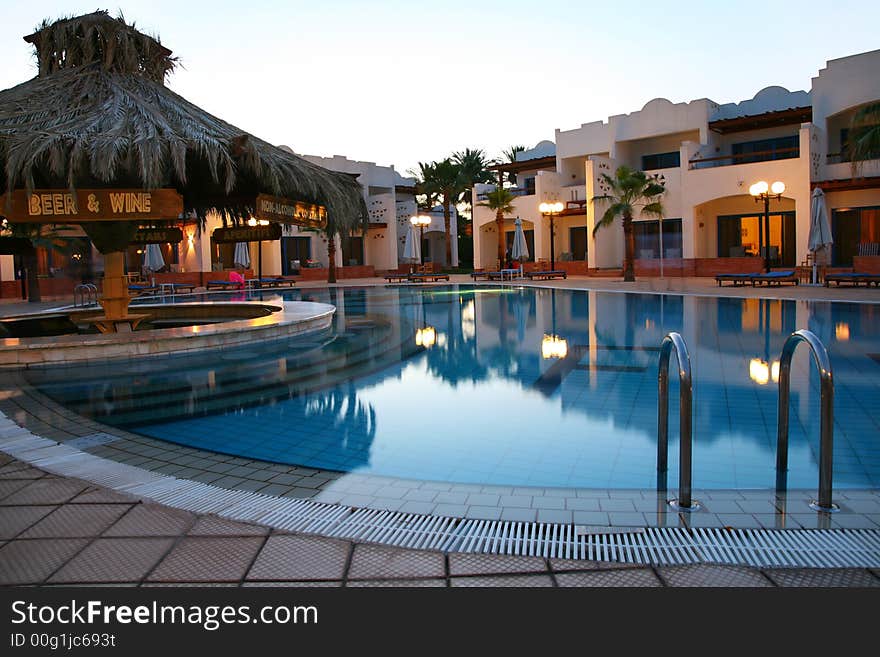 Evening shot of swimming pool in tropical hotel