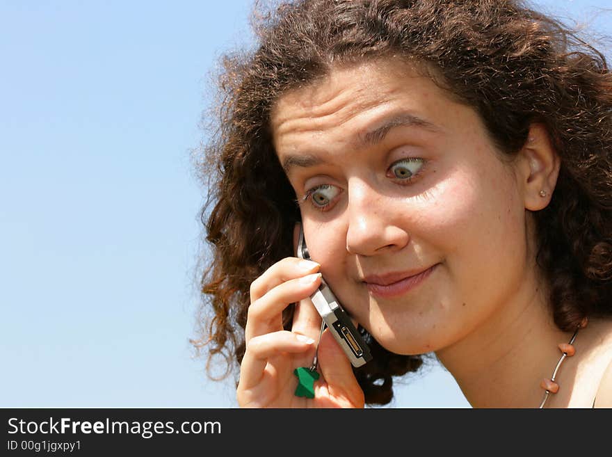 Amazed girl with cell phone against a blue sky