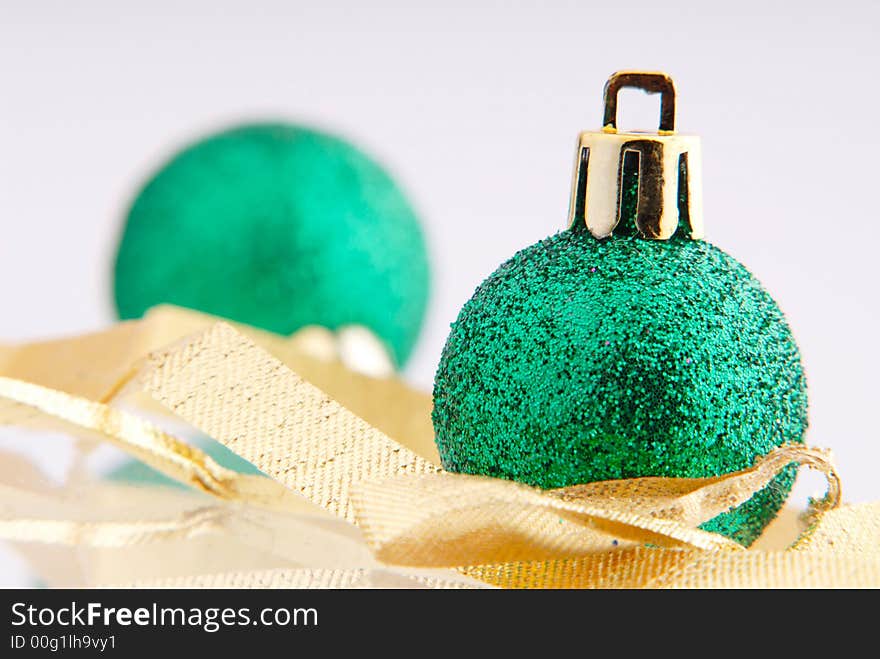 Two balls of green color and golden tape, New Year's toy. Two balls of green color and golden tape, New Year's toy