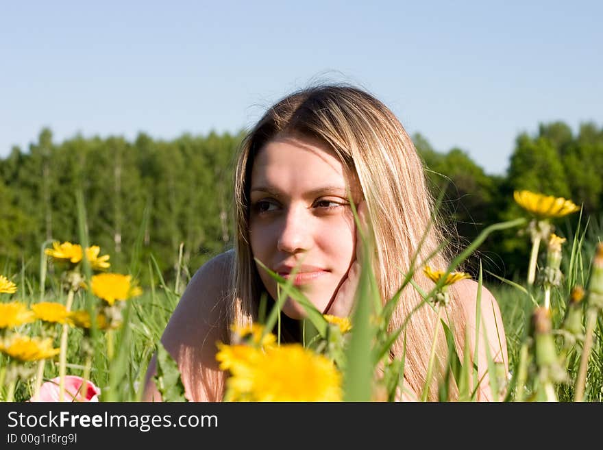 Girl lays on glade with dandelions. Girl lays on glade with dandelions