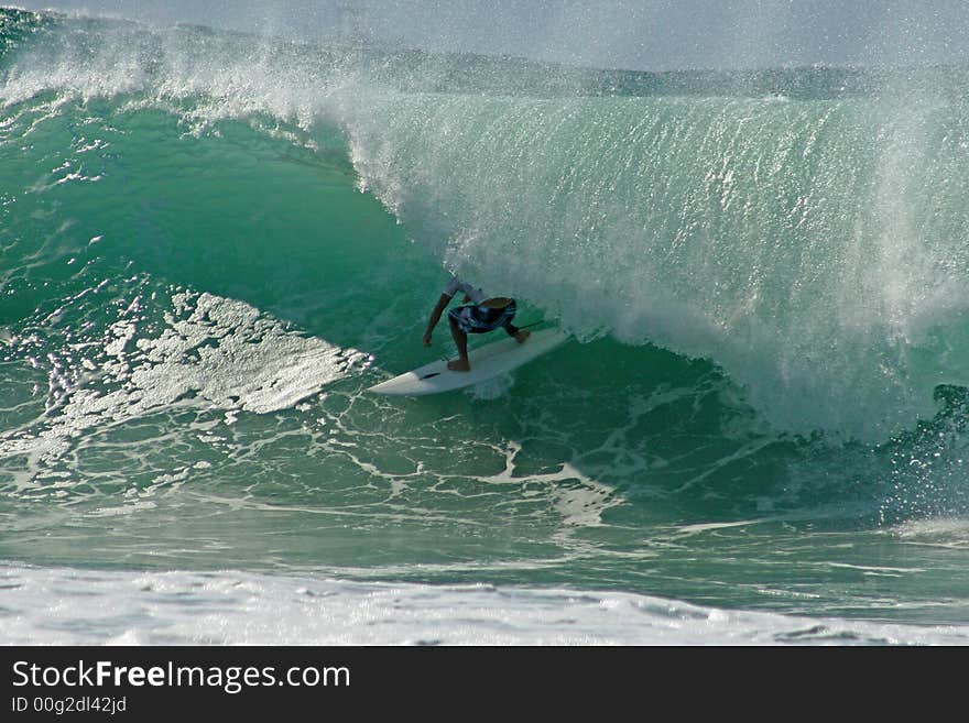 A male surfer riding a wave. A male surfer riding a wave