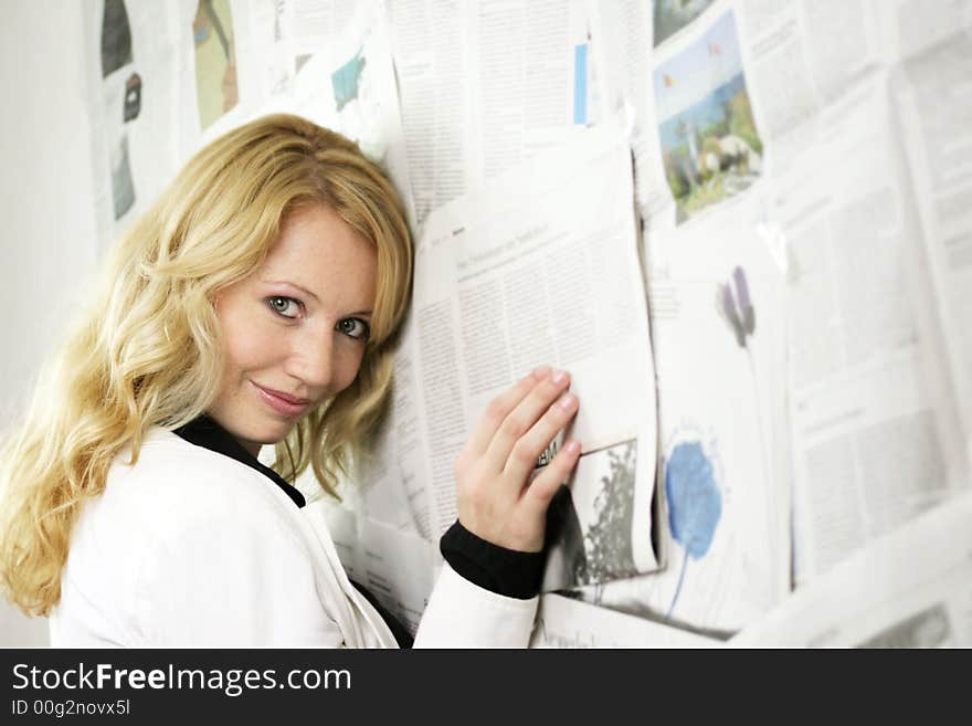 Portrait of a fresh and beautiful blond woman with a lot of newspapers. Portrait of a fresh and beautiful blond woman with a lot of newspapers