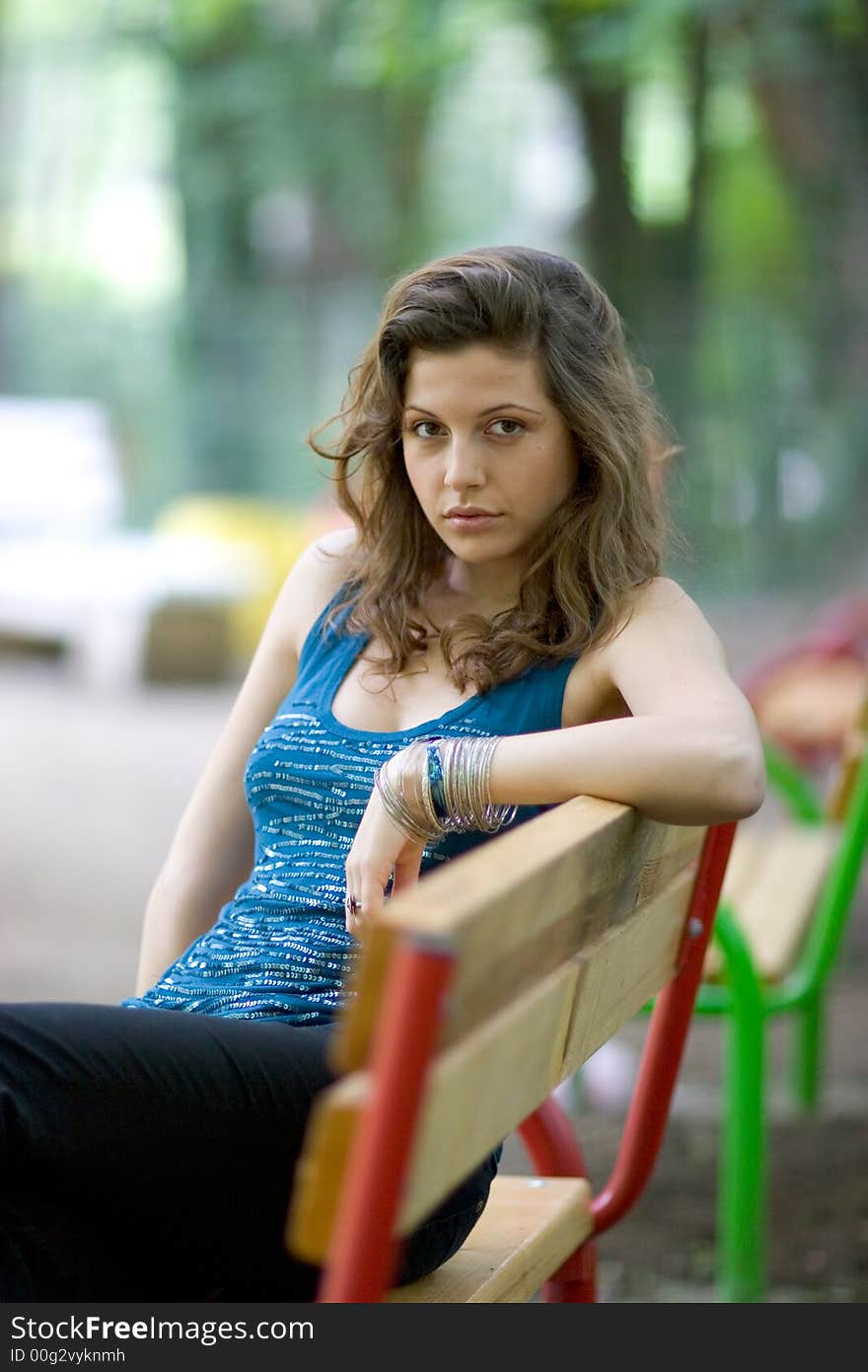 Beautiful woman sitting on a seat at park. Beautiful woman sitting on a seat at park