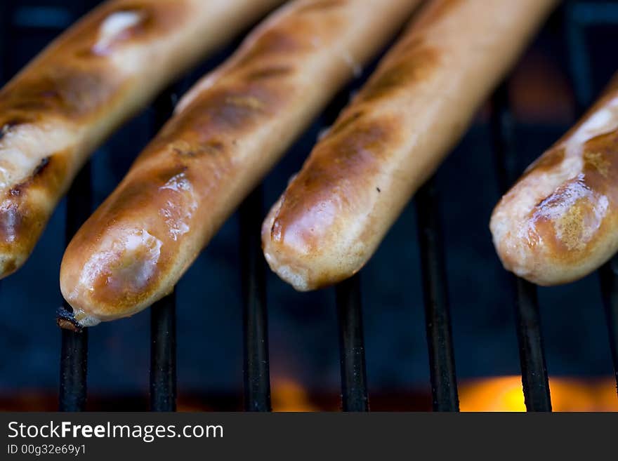 A summer bbq staple hotdogs on the grill close up shots shallow depth of view nice grill marks. A summer bbq staple hotdogs on the grill close up shots shallow depth of view nice grill marks