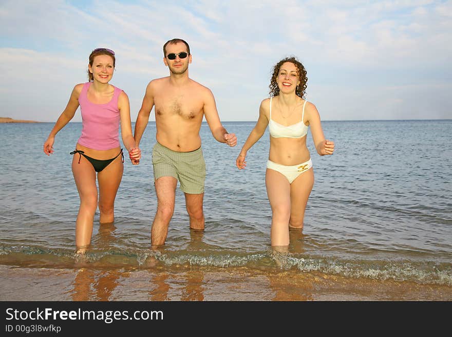 Man and two girls leave the sea