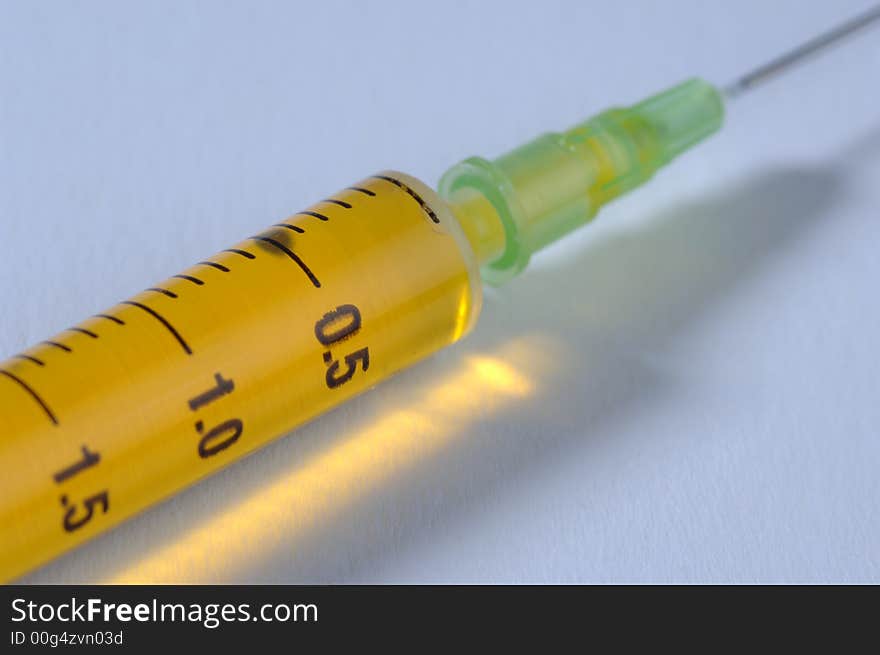 Syringe with yellow vaccine isolated. Syringe with yellow vaccine isolated