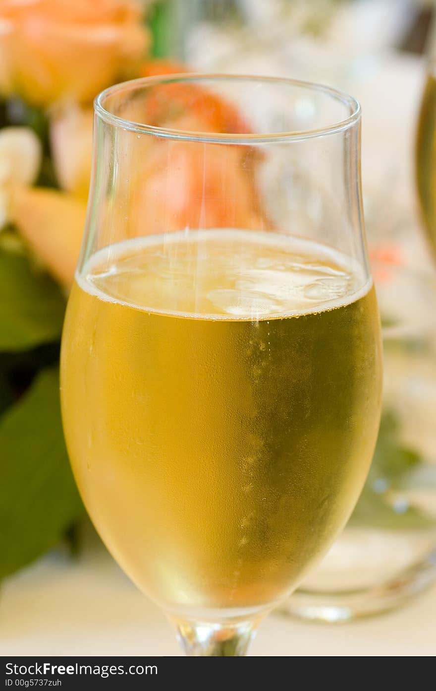 A Glass of Champagne with flowers in the background