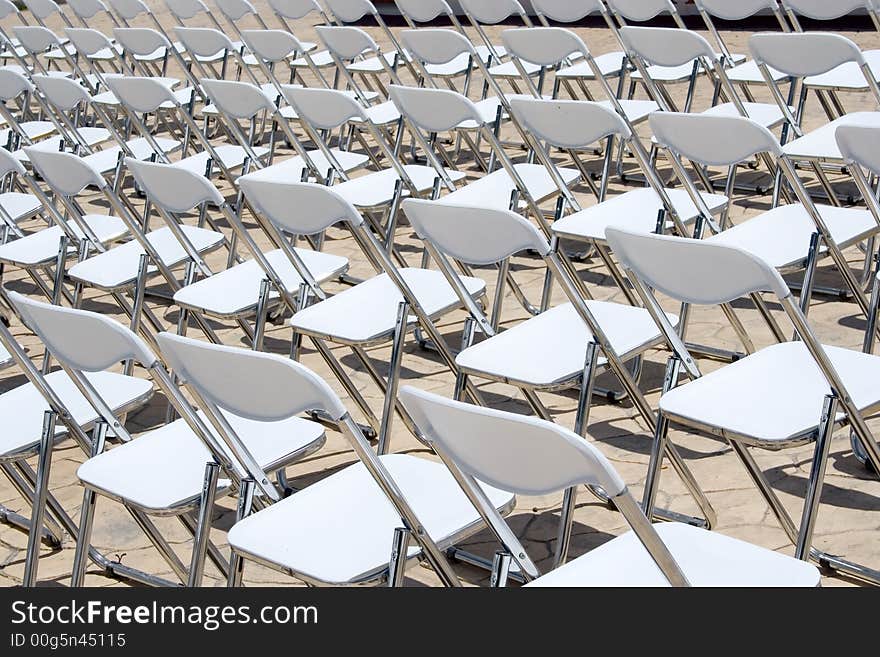 An array of white chairs waiting for the audience of an open-air event