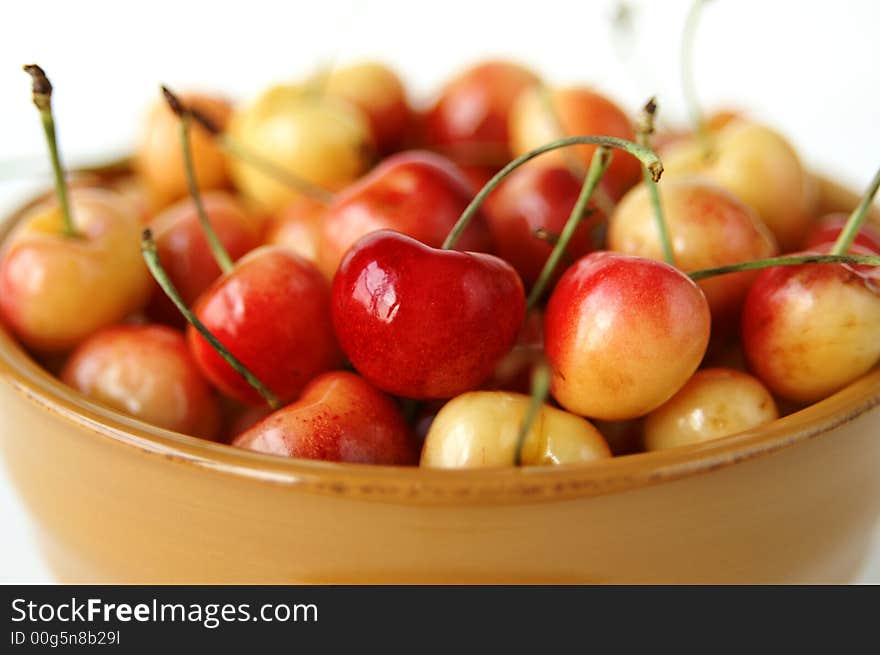 A still life of a bowl full of ripe yellow cherries. A still life of a bowl full of ripe yellow cherries