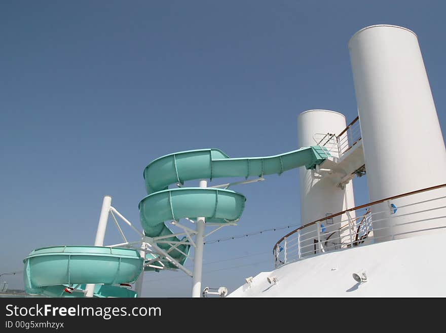 Green slide on a white ship against a blue sky