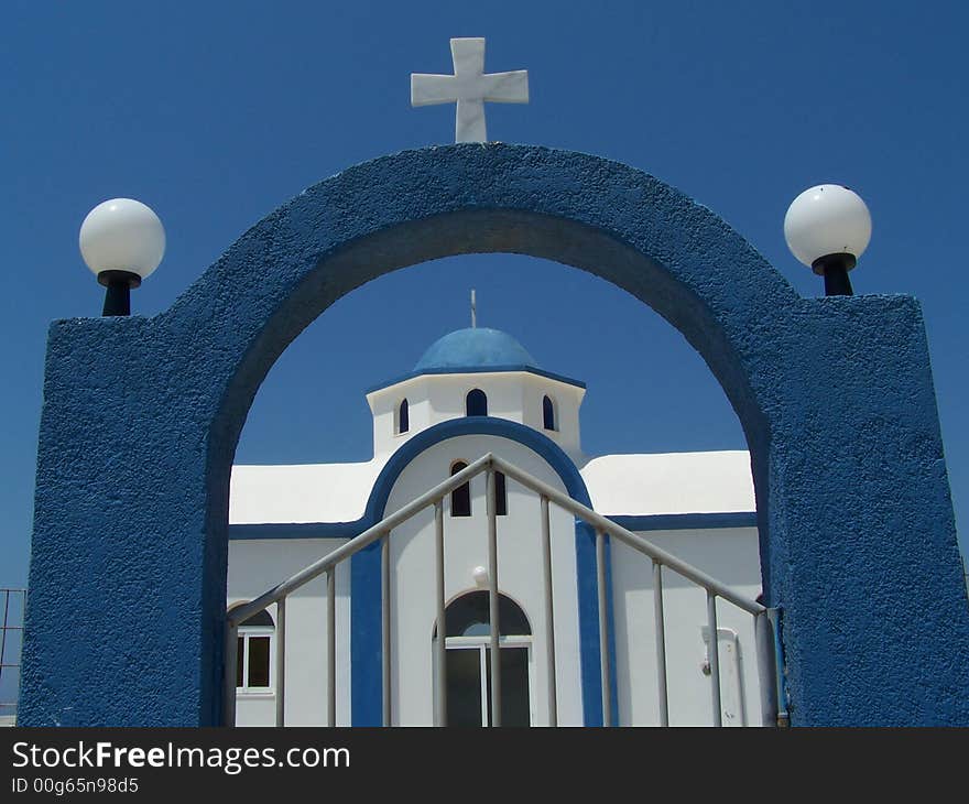 Greek church and entrance gate with clear blue sky