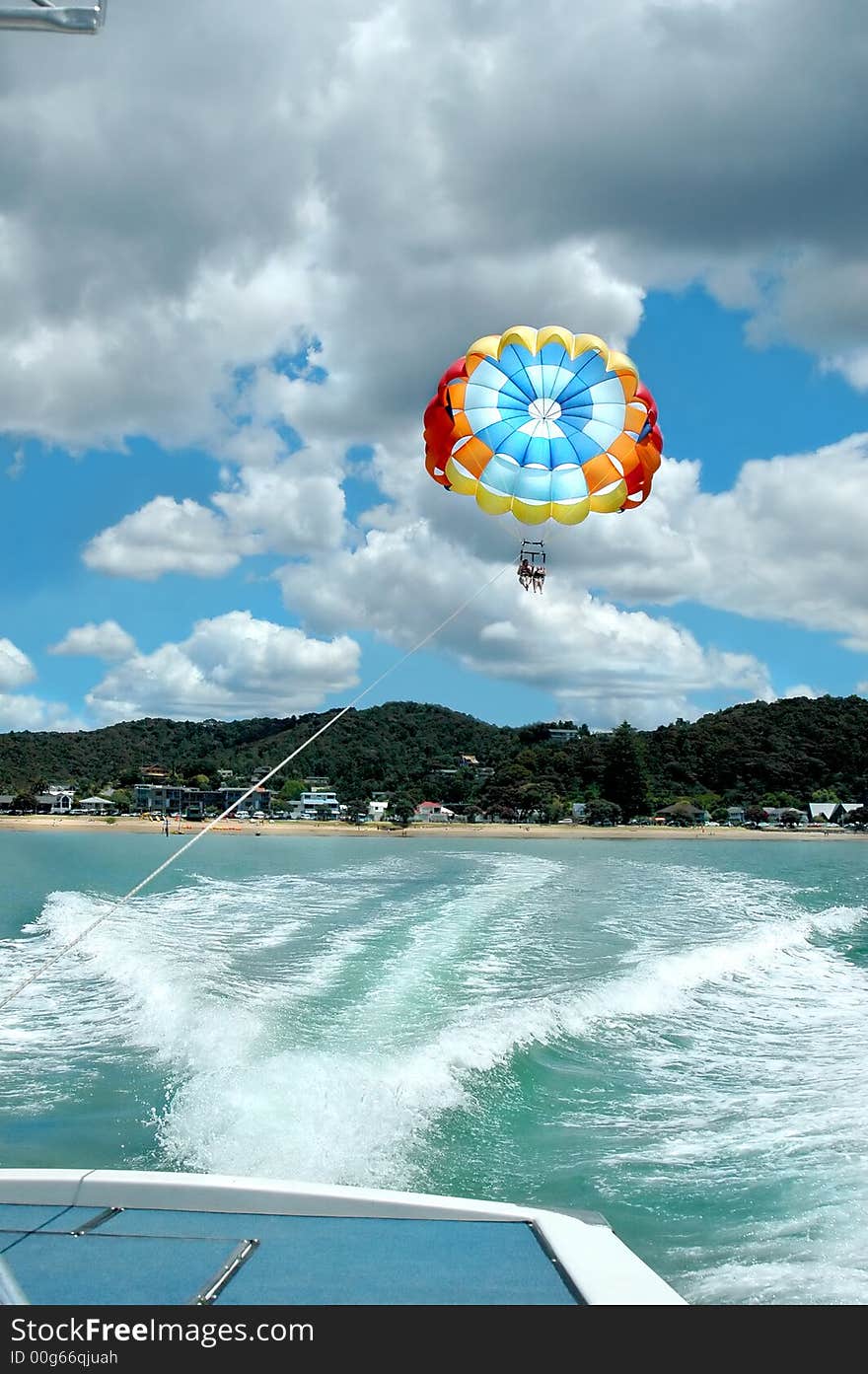 A couple on a parchute behind a speed boat. A couple on a parchute behind a speed boat