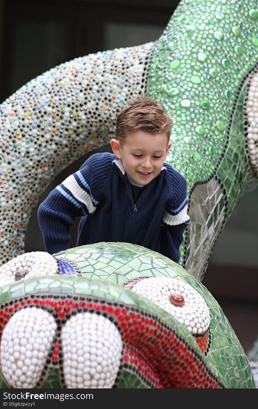 Little boy climbing on playground dragon. Little boy climbing on playground dragon.