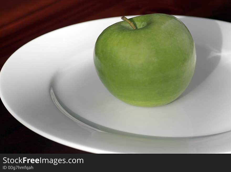 One Green Apple Standing On A White Plate