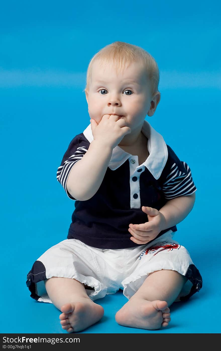 The small smiling child in studio, on a blue background. The small smiling child in studio, on a blue background