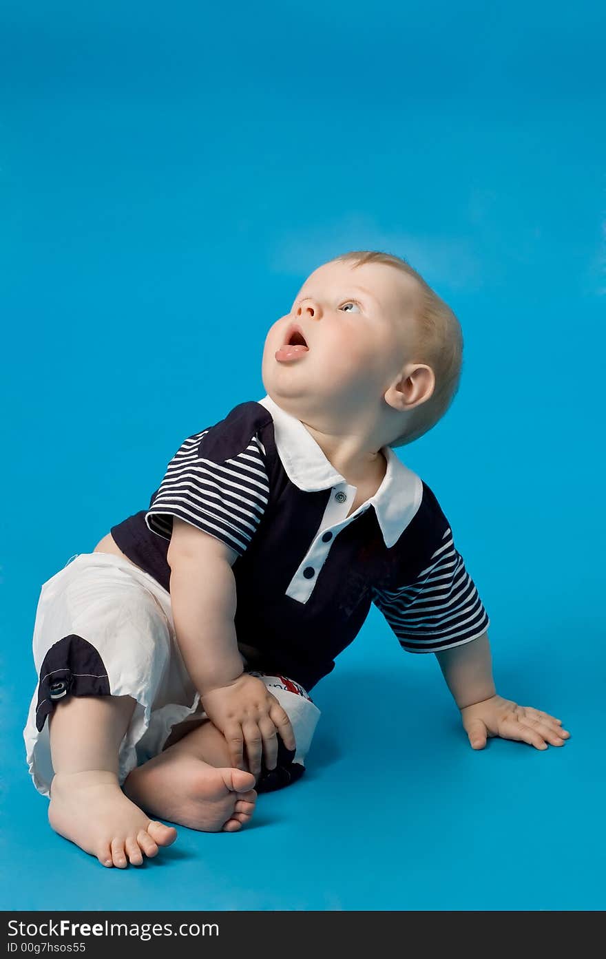 The small smiling child in studio, on a blue background. The small smiling child in studio, on a blue background