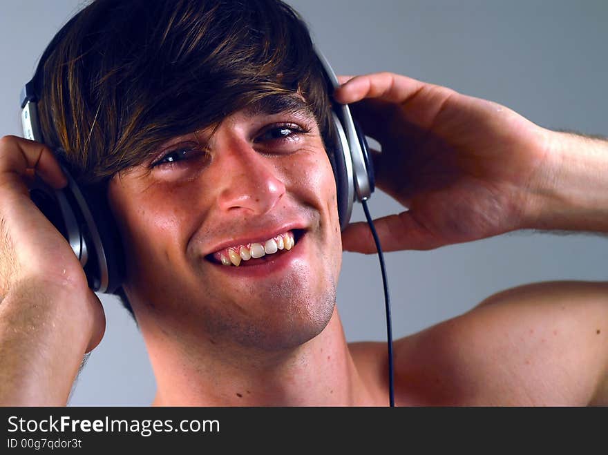 Young man enjoying listening to music on headphones. Young man enjoying listening to music on headphones.