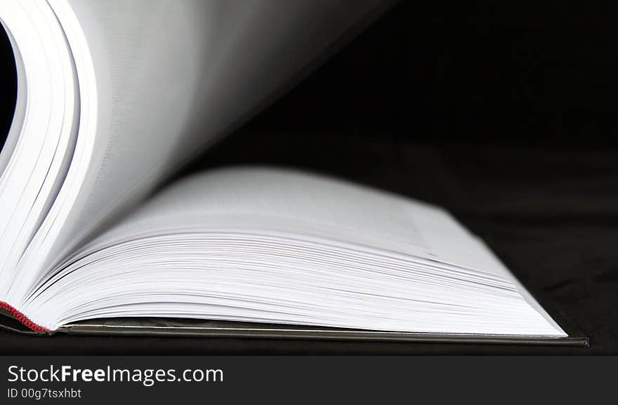 Book with moving sheets on a black background