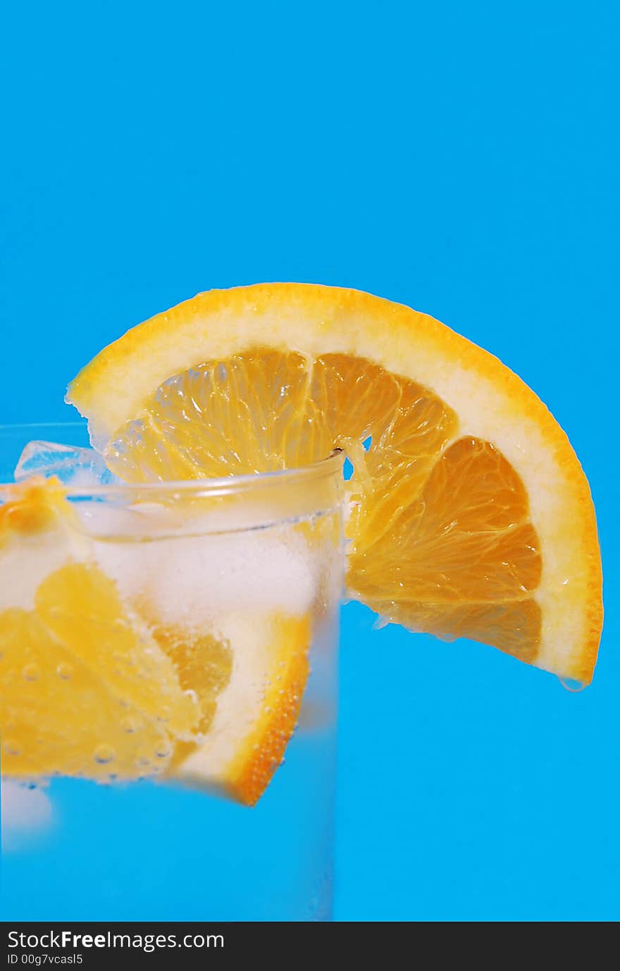 Bright juicy oranges in a glass on a blue background. Bright juicy oranges in a glass on a blue background