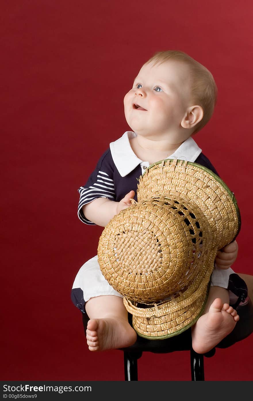 The small smiling child in studio, on a red background. The small smiling child in studio, on a red background