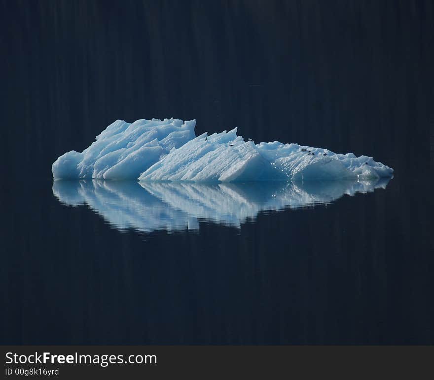 A small ice burg reflected in the pacific ocean. A small ice burg reflected in the pacific ocean