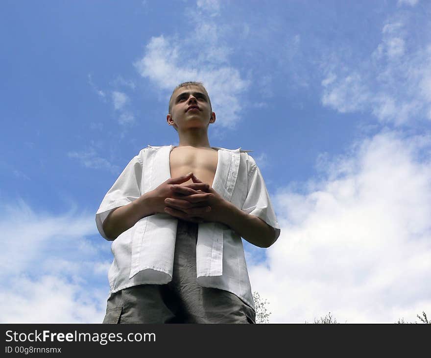 The boy stands on a sky background. The boy stands on a sky background