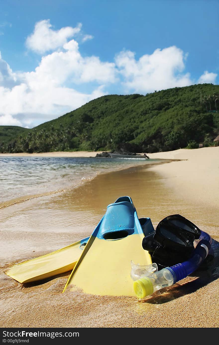 Image of sandy beach with snorkle, eye goggles and flippers. Image of sandy beach with snorkle, eye goggles and flippers