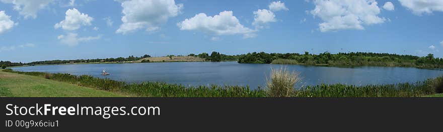 This is a lakeveiw with the clouds and sky and water, this is a panoramic