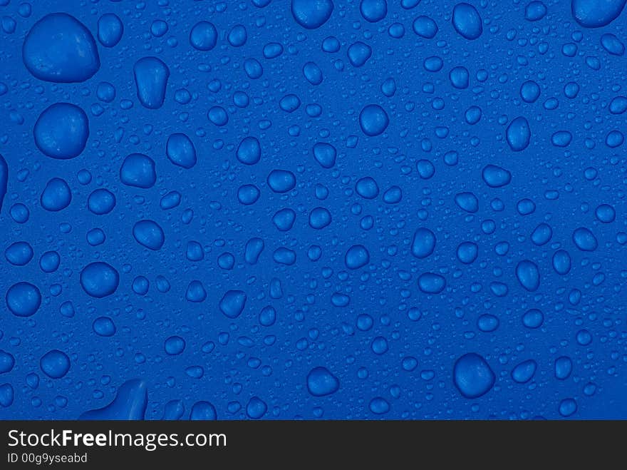 Raindrops on a metallic blue plastic surface. Raindrops on a metallic blue plastic surface