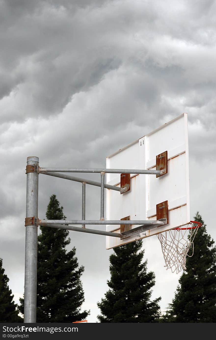 Basketball hoop with dark ominous clouds overhead. Basketball hoop with dark ominous clouds overhead