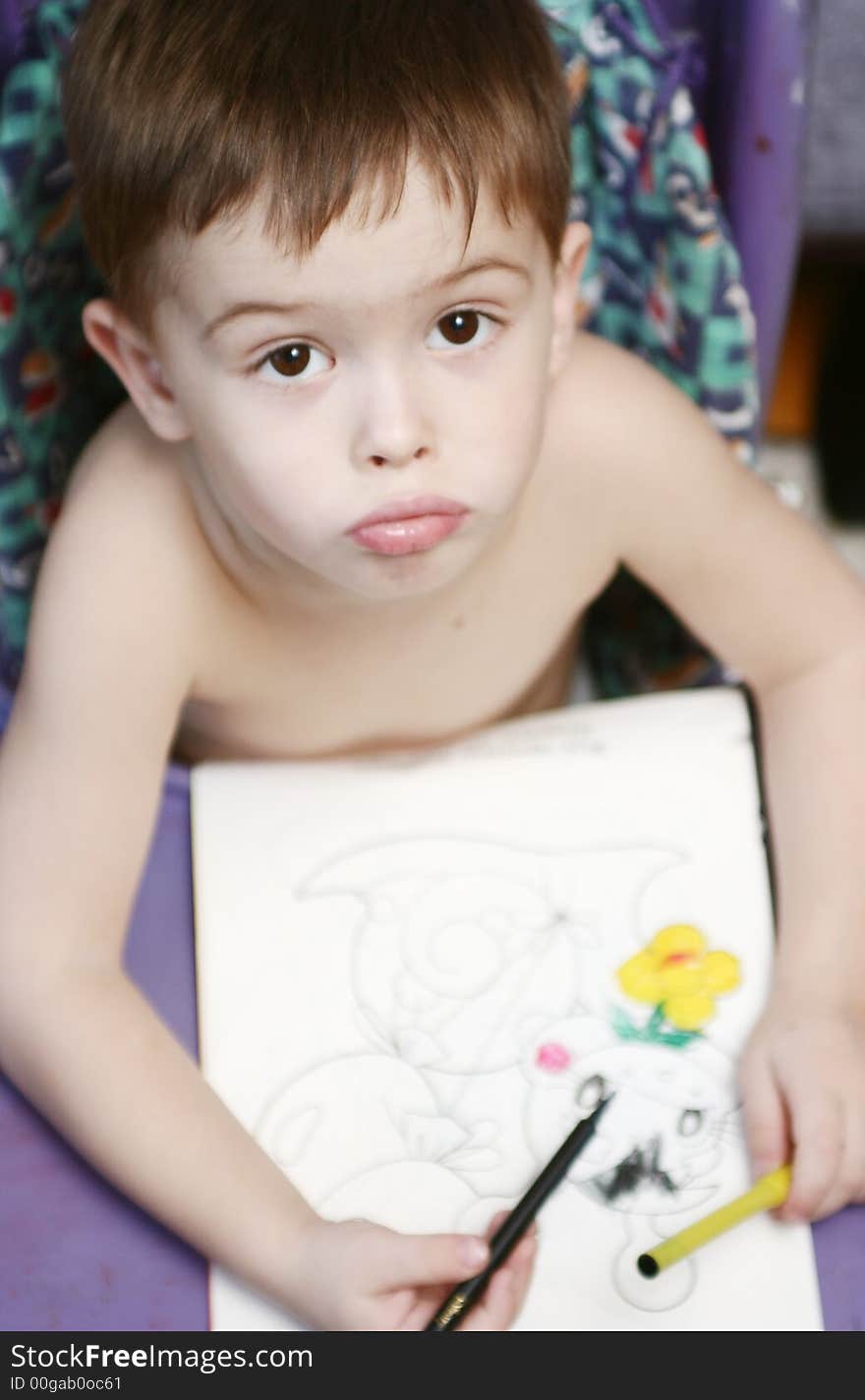 The sight of the boy which sits at a table and draws