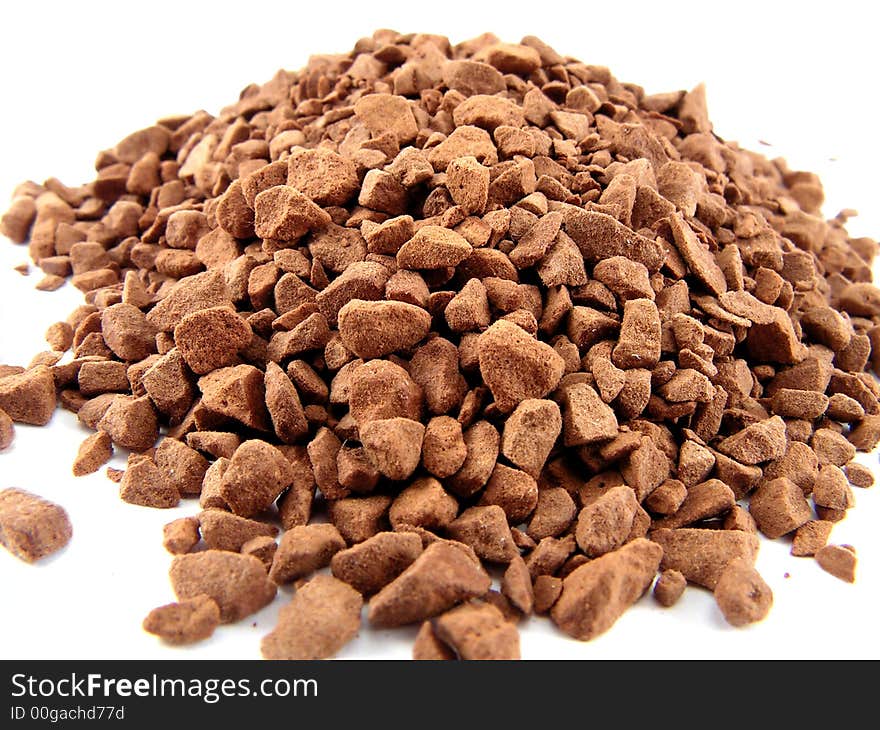 The heap of ground coffee, is photographed close up on a white background.