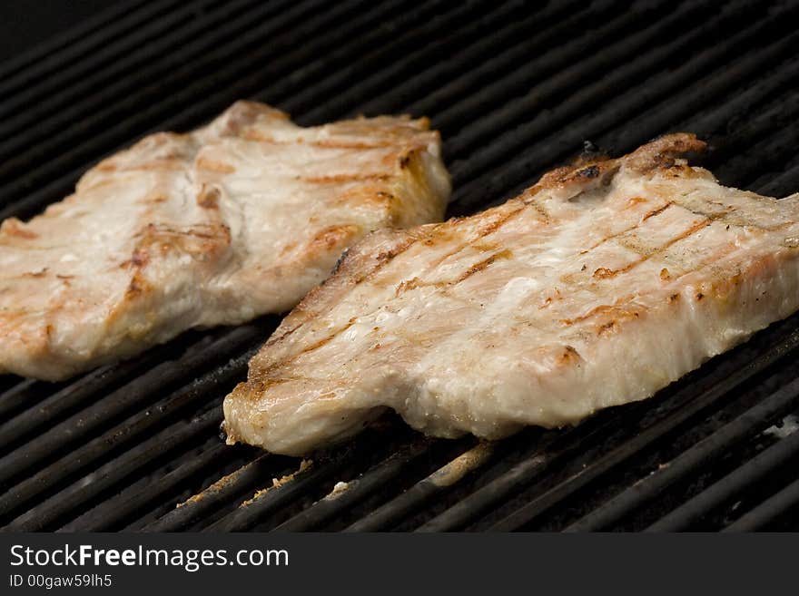 Pork chops on the grill.  Grill marks and close up detail. Pork chops on the grill.  Grill marks and close up detail